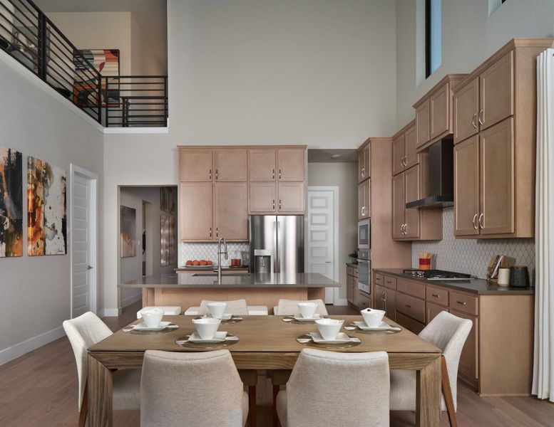 Dining area featuring light wood finished floors and a towering ceiling