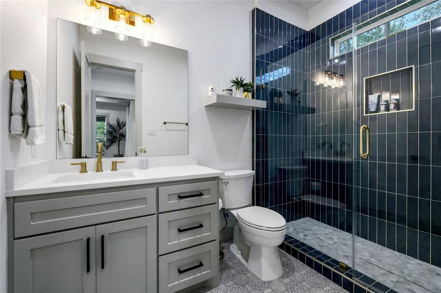 Bath #3 has frameless glass shower with gold accents. This bath is located to the left of the kitchen.