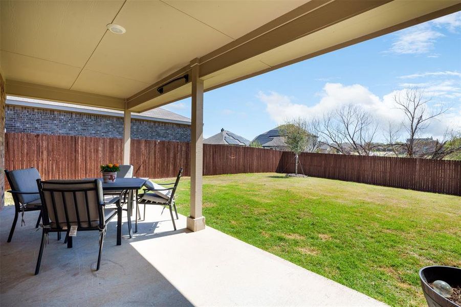 Large covered patio and large yard completely private with stained wood fencing.