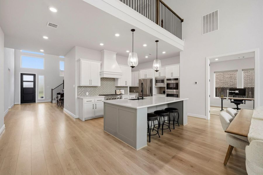 Deep pots-and-pans drawers provide sleek, custom-style storage for cookware and dishes, while the stainless steel Samsung French-door refrigerator remains with the home, complementing the kitchen’s elevated finishes and adding desirable move-in-ready convenience.
