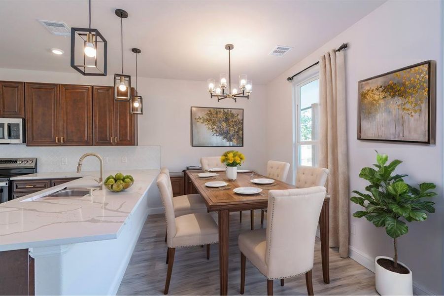 Dining room featuring light hardwood / wood-style floors, sink, and a notable chandelier