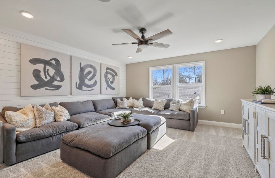 The upstairs loft, bathed in sunlight from the large window, provides a tranquil retreat for reading or reflection.