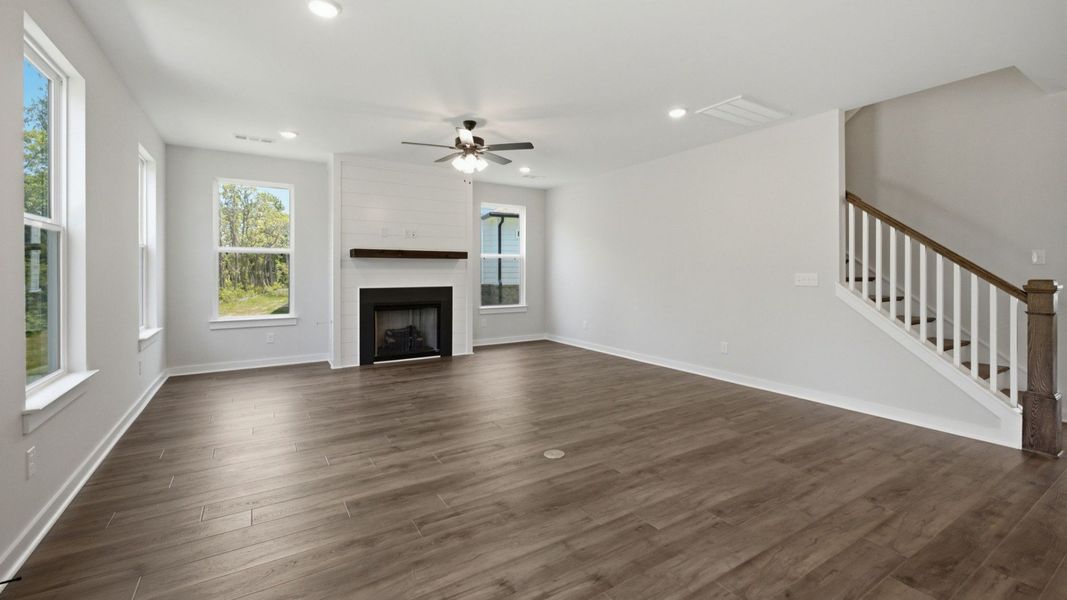 Gathering room with ceiling fan, fireplace, and hard surface flooring