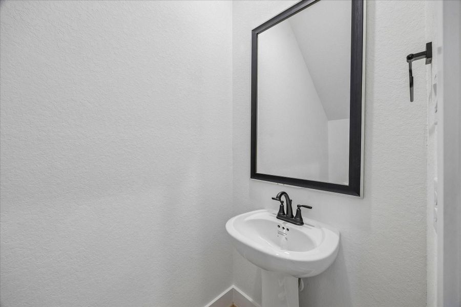 A convenient powder bath is thoughtfully tucked beneath the staircase.