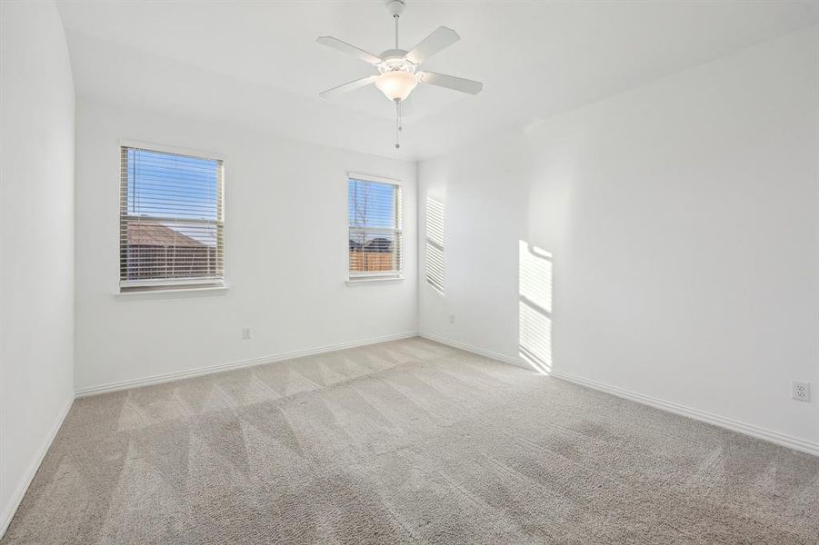 Carpeted empty Primary Bedroom with ceiling fan and plenty of natural light