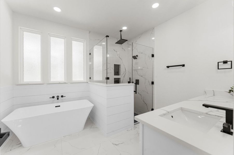 Spa-inspired bath with walk-in shower, soaking tub, double vanities, quartz counters, and luxury finishes. Spa-inspired bath with walk-in shower, soaking tub, double vanities, quartz counters, and luxury finishes.