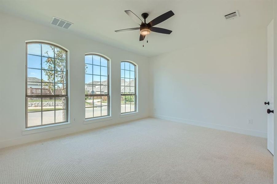 Carpeted empty room with ceiling fan