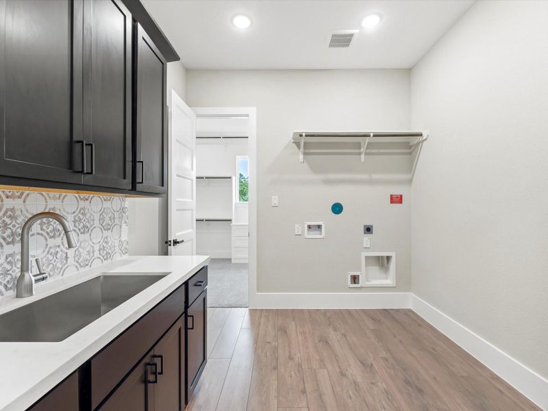 Spacious utility room with sink and cabinetry for everyday essentials. Spacious utility room with sink and cabinetry for everyday essentials.