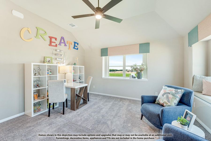 Children's craft room with vaulted ceiling, ceiling fan, desk, white shelving unit, and blue seating area with carpet flooring. Children's craft room with vaulted ceiling, ceiling fan, desk, white shelving unit, and blue seating area with carpet flooring.