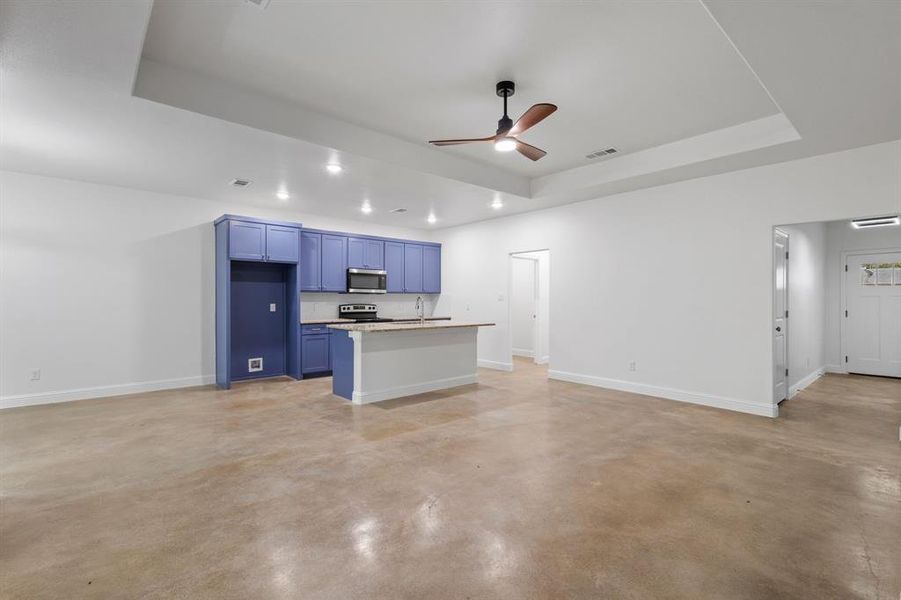 Kitchen featuring blue cabinetry, sink, stainless steel appliances, and a tray ceiling