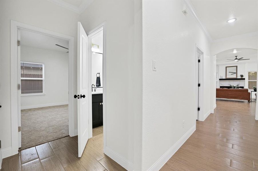 Corridor with wood-style flooring and ornamental molding