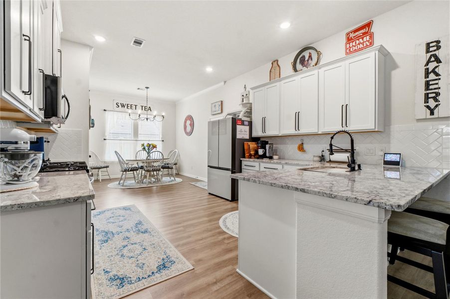 Designed for both everyday living and effortless entertaining, this bright and inviting kitchen features generous counter space, timeless finishes, and an open flow into the dining area—perfect for gathering over coffee, sweet tea, or home-cooked meals.