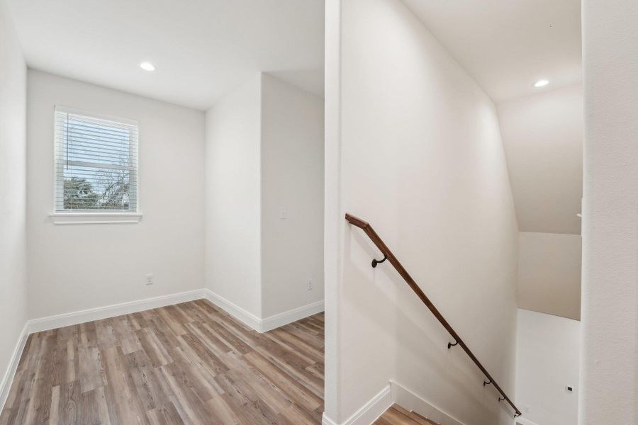 Staircase featuring recessed lighting, baseboards, and luxury vinyl floor Staircase featuring recessed lighting, baseboards, and luxury vinyl floor