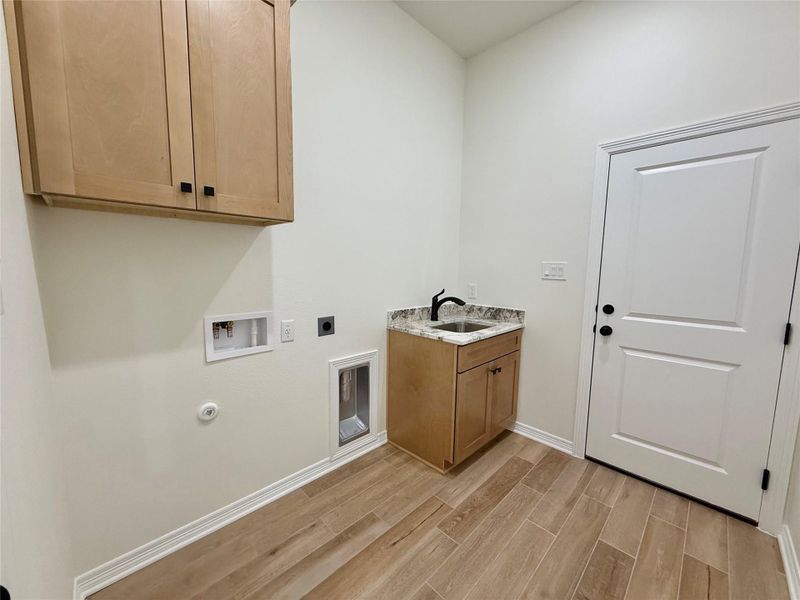 Laundry area with wood tiled floors, cabinet space, gas dryer hookup, electric dryer hookup, and hookup for a washing machine