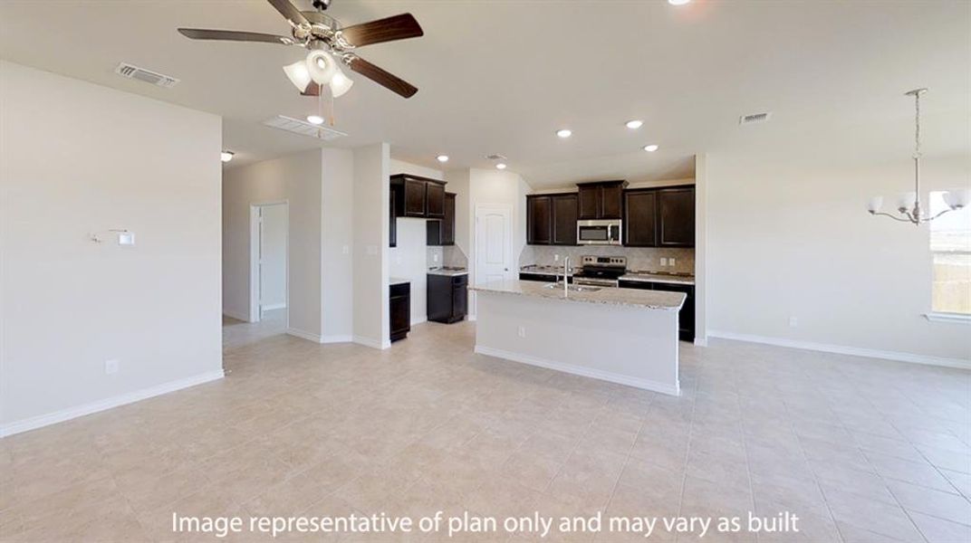 Kitchen featuring open floor plan, light stone countertops, hanging light fixtures, an island with sink, and dark brown cabinetry Kitchen featuring open floor plan, light stone countertops, hanging light fixtures, an island with sink, and dark brown cabinetry