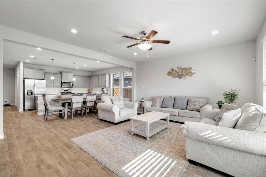 Living room featuring recessed lighting, light wood-type flooring, and a ceiling fan