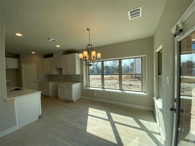 Breakfast cafe area with window seat, decorative Brushed Nickel chandelier, and rich hardwood floors(not stained yet.)