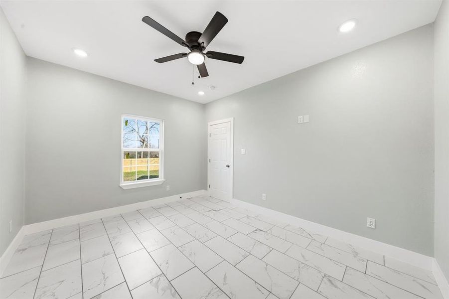 Spare room featuring light marble finish floors, ceiling fan, and recessed lighting