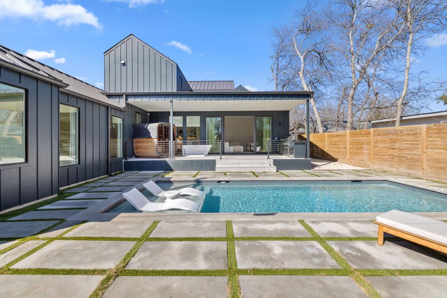 Rear view of house featuring board and batten siding, a patio, and a standing seam roof