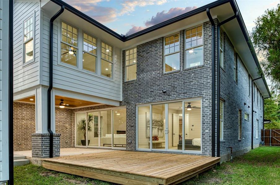 Rear view of house featuring a deck and ceiling fan