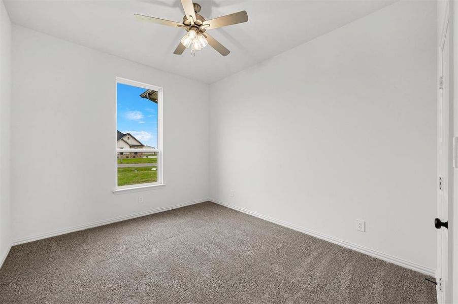 Spare room featuring ceiling fan and carpet