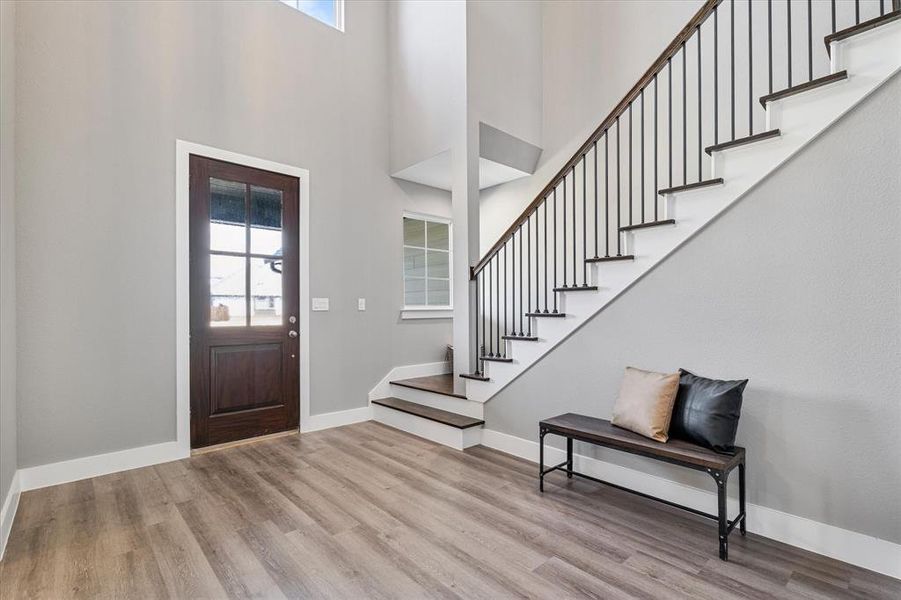 Foyer entrance with a high ceiling and light wood-type flooring