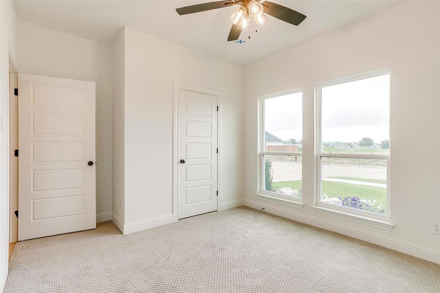 Unfurnished bedroom featuring ceiling fan, light colored carpet, and a closet