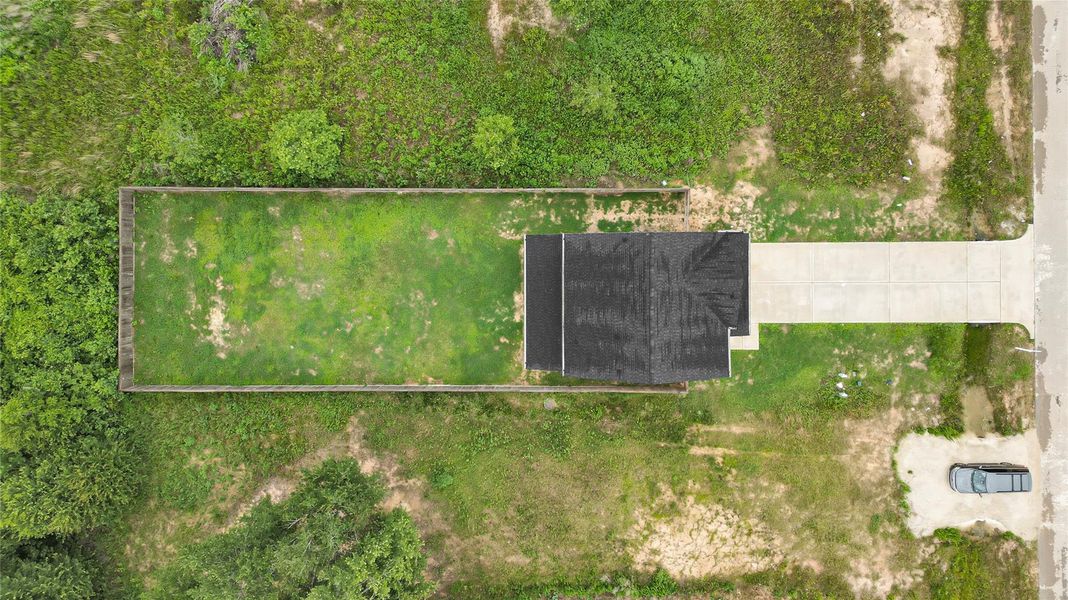 This aerial view showcases the full layout of the property, highlighting it’s generous lot and long driveway.