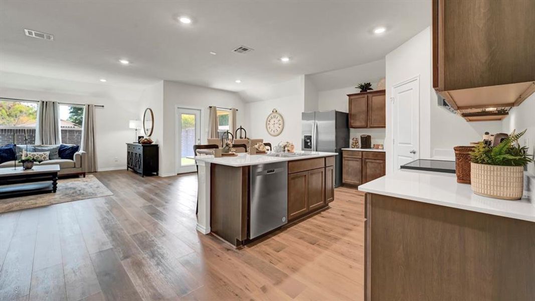 Kitchen with open floor plan, recessed lighting, stainless steel appliances, an island with sink, and light wood-type flooring
