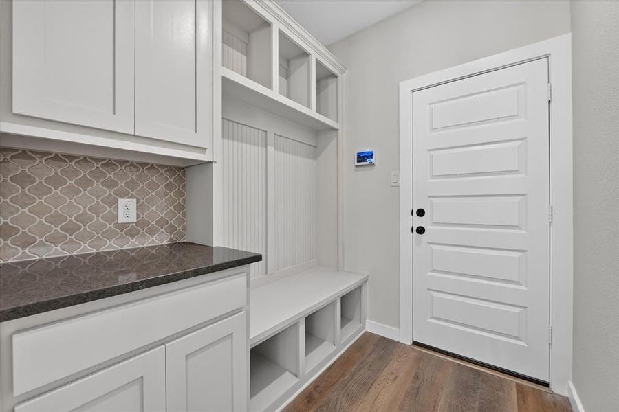 Built-in white cabinetry and shelving system featuring a wood-finish bench Built-in white cabinetry and shelving system featuring a wood-finish bench