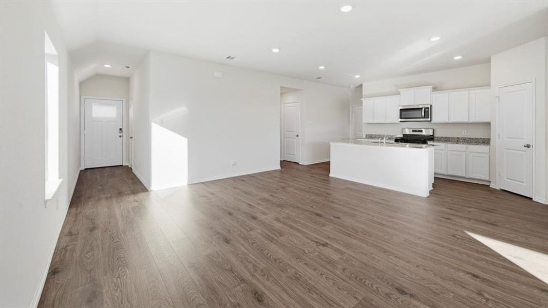 Kitchen featuring white cabinets, an island with sink, recessed lighting, open floor plan, and stainless steel appliances Kitchen featuring white cabinets, an island with sink, recessed lighting, open floor plan, and stainless steel appliances