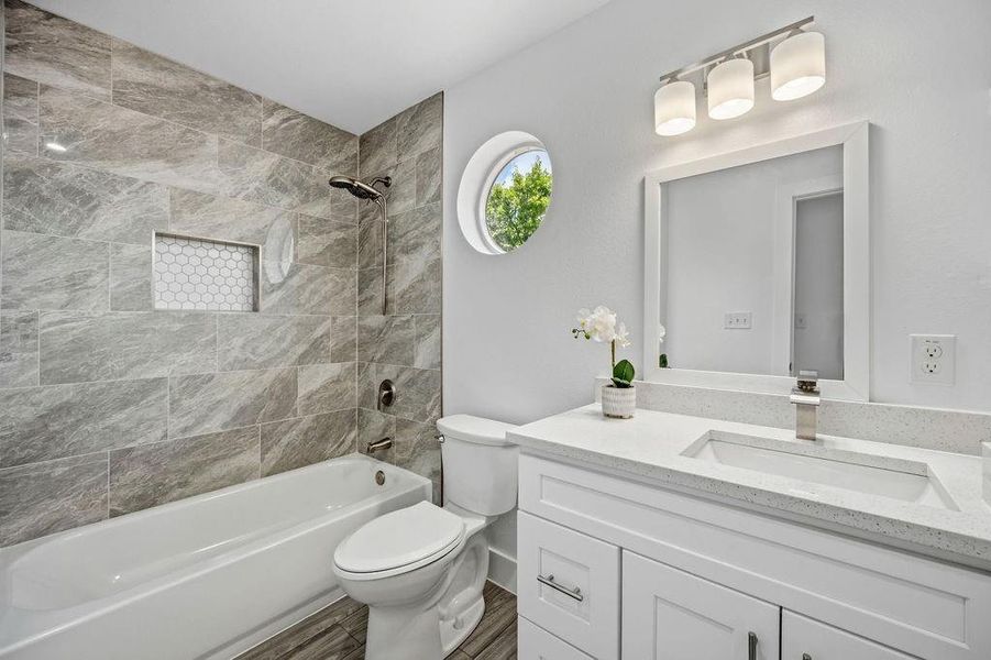 Bathroom featuring a white vanity with a light-colored countertop, an undermount sink, and a framed mirror Bathroom featuring a white vanity with a light-colored countertop, an undermount sink, and a framed mirror