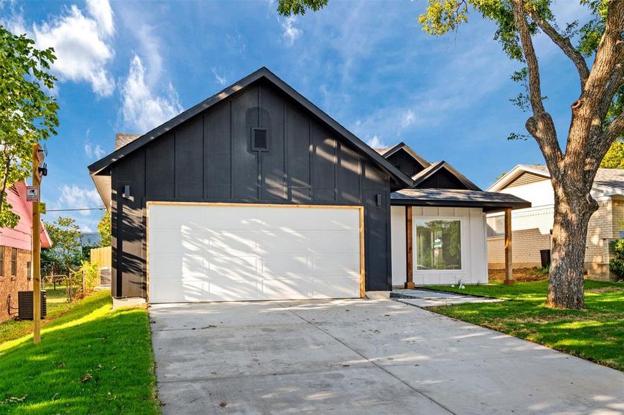 View of front of house featuring a garage, a front yard