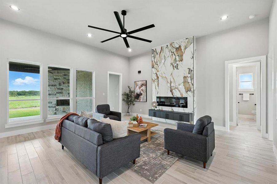 Living area with a ceiling fan, recessed lighting, and light wood-type flooring Living area with a ceiling fan, recessed lighting, and light wood-type flooring