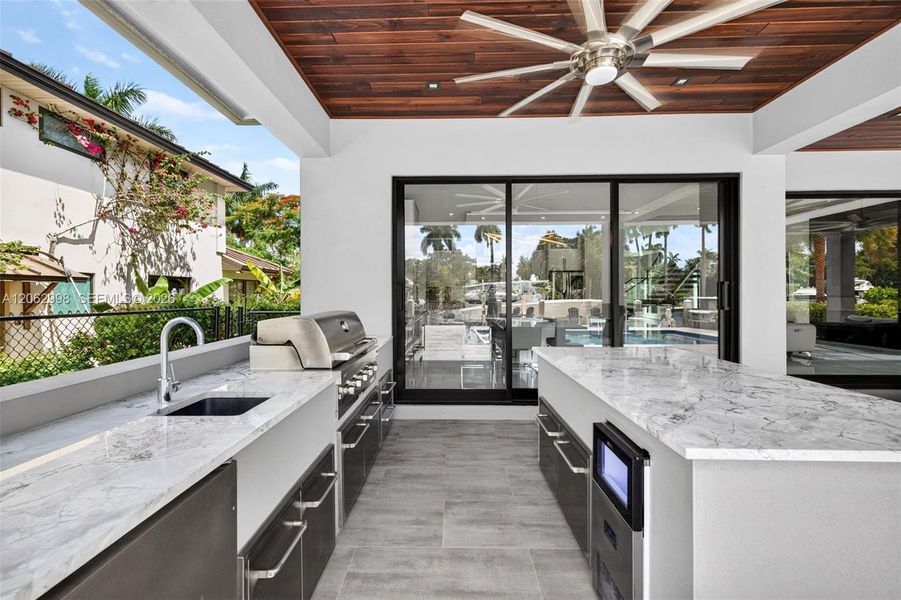 Covered patio w/ T&G ceilings, fans, fire pit seating and outdoor kitchen overlooks the gorgeous wide New River views and pool area