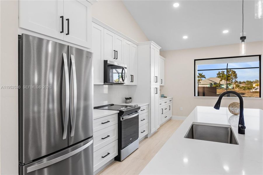 GORGEOUS CHEF'S KITCHEN w/ SPACIOUS QUARTS COUNTERTOP ISLAND w/ undermount LARGE SINK & SLEEK MATTE-BLACK gooseneck FAUCET.