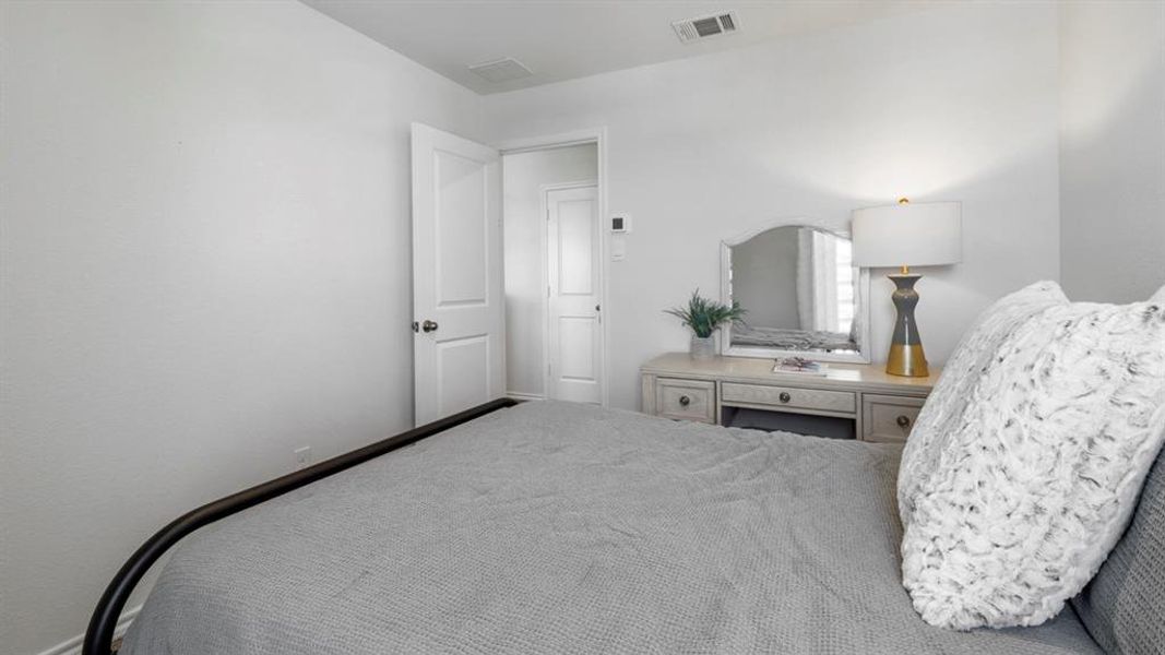 Neutral-toned bedroom featuring white walls and a white interior door