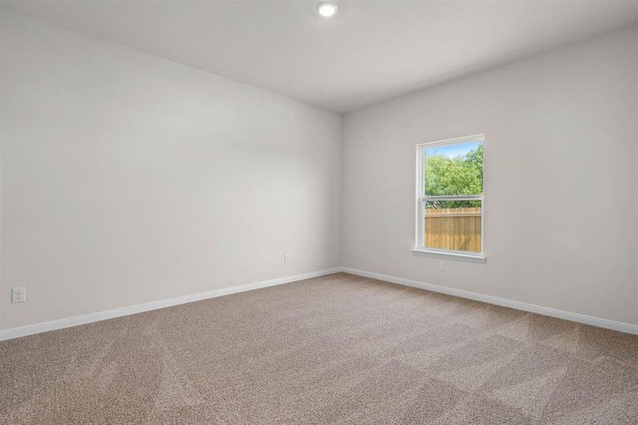 Spare room featuring baseboards and light carpet