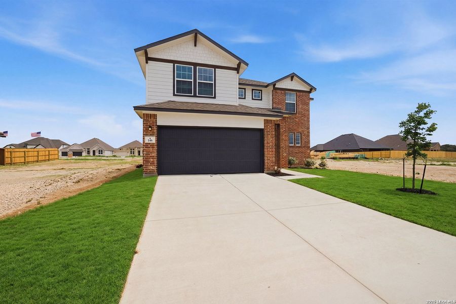 Front exterior of a new home in Megan's Landing, Castroville, TX, highlighting curb appeal (Image 21).