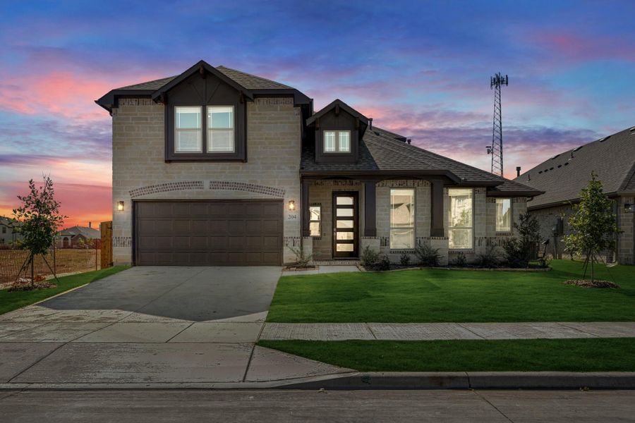 Two-story home with light stone exterior, two-car garage, and green front lawn at dusk Two-story home with light stone exterior, two-car garage, and green front lawn at dusk