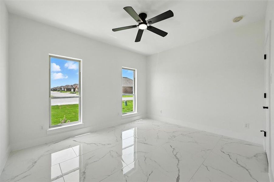 Empty room with light marble finish floors and ceiling fan