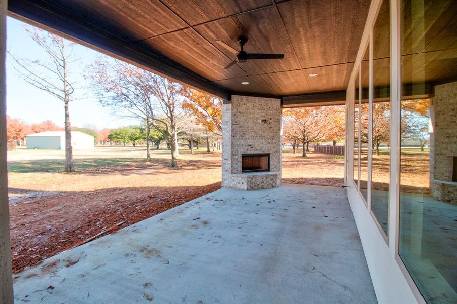 View of patio / terrace with an outdoor stone fireplace and ceiling fan