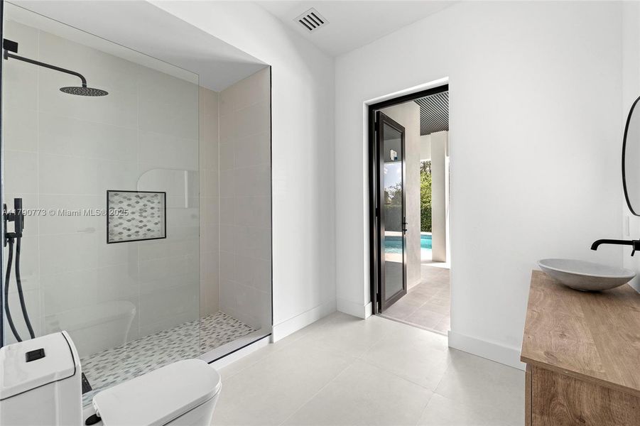 Cabana bath featuring a spacious rainfall shower and a handheld showerhead, combining luxury and convenience for seamless indoor-outdoor living. Cabana bath featuring a spacious rainfall shower and a handheld showerhead, combining luxury and convenience for seamless indoor-outdoor living.