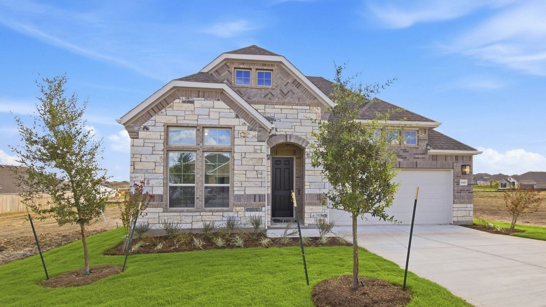 Front exterior of a new home in Carillon, Manor, TX, highlighting curb appeal (Image 21).