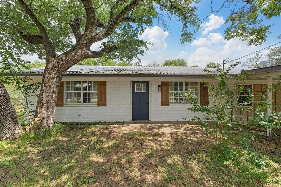 Ranch-style home featuring brick siding and metal roof Ranch-style home featuring brick siding and metal roof
