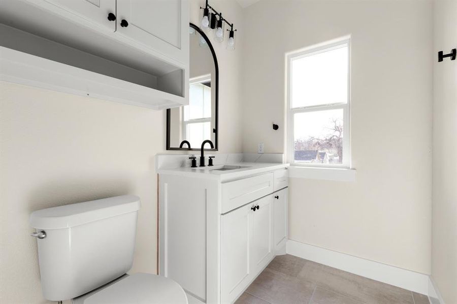 Bathroom featuring tile patterned flooring, vanity, and toilet