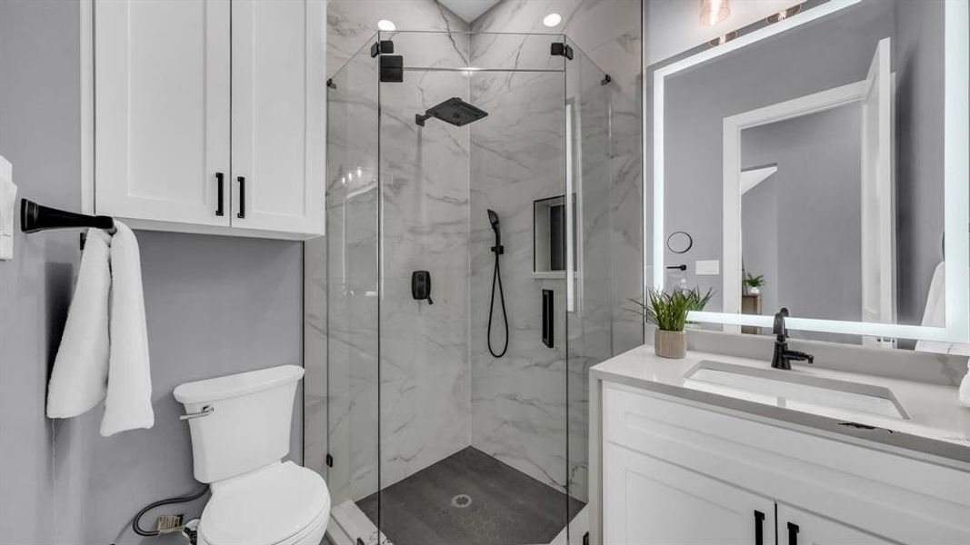 Full bathroom featuring vanity and a marble finish shower