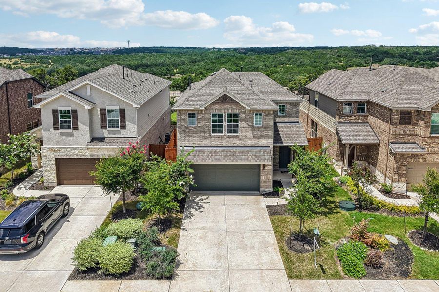 A classic brick exterior graces this two-story residence with an attached garage and manicured landscaping.
