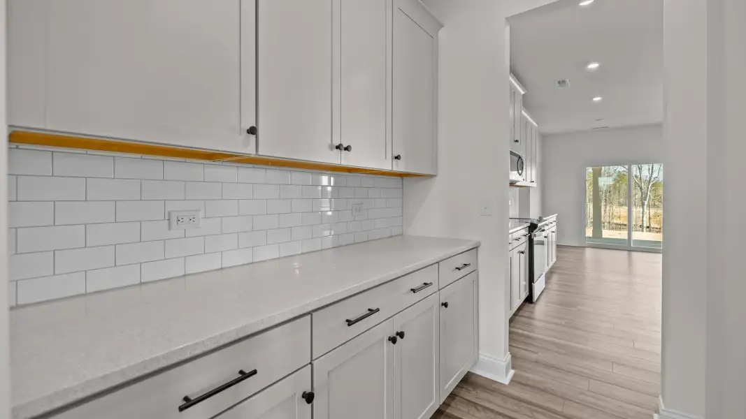Elegant pass-through Butler's pantry with tile backsplash and premium cabinets, in the Norris Design by DRB Homes in York, SC Elegant pass-through Butler's pantry with tile backsplash and premium cabinets, in the Norris Design by DRB Homes in York, SC
