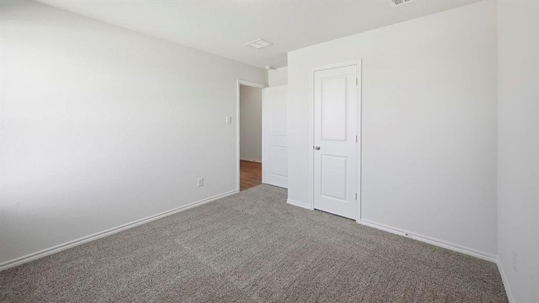 Carpeted empty room with baseboards